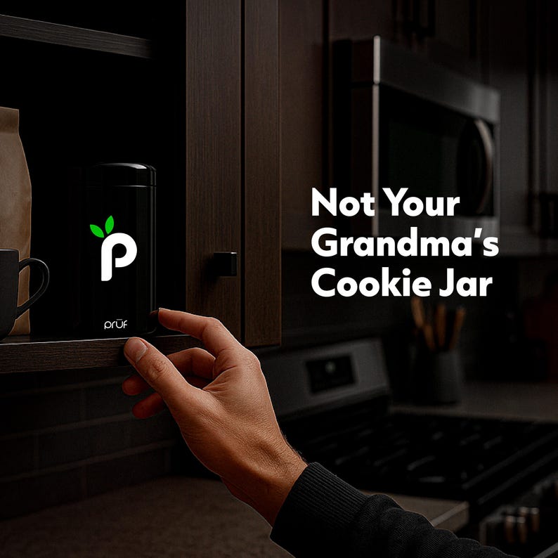 May include: A black cookie jar with a white "p" logo and green leaf design is displayed on a shelf. The text "Not Your Grandma's Cookie Jar" is visible. The jar is being held by a person.