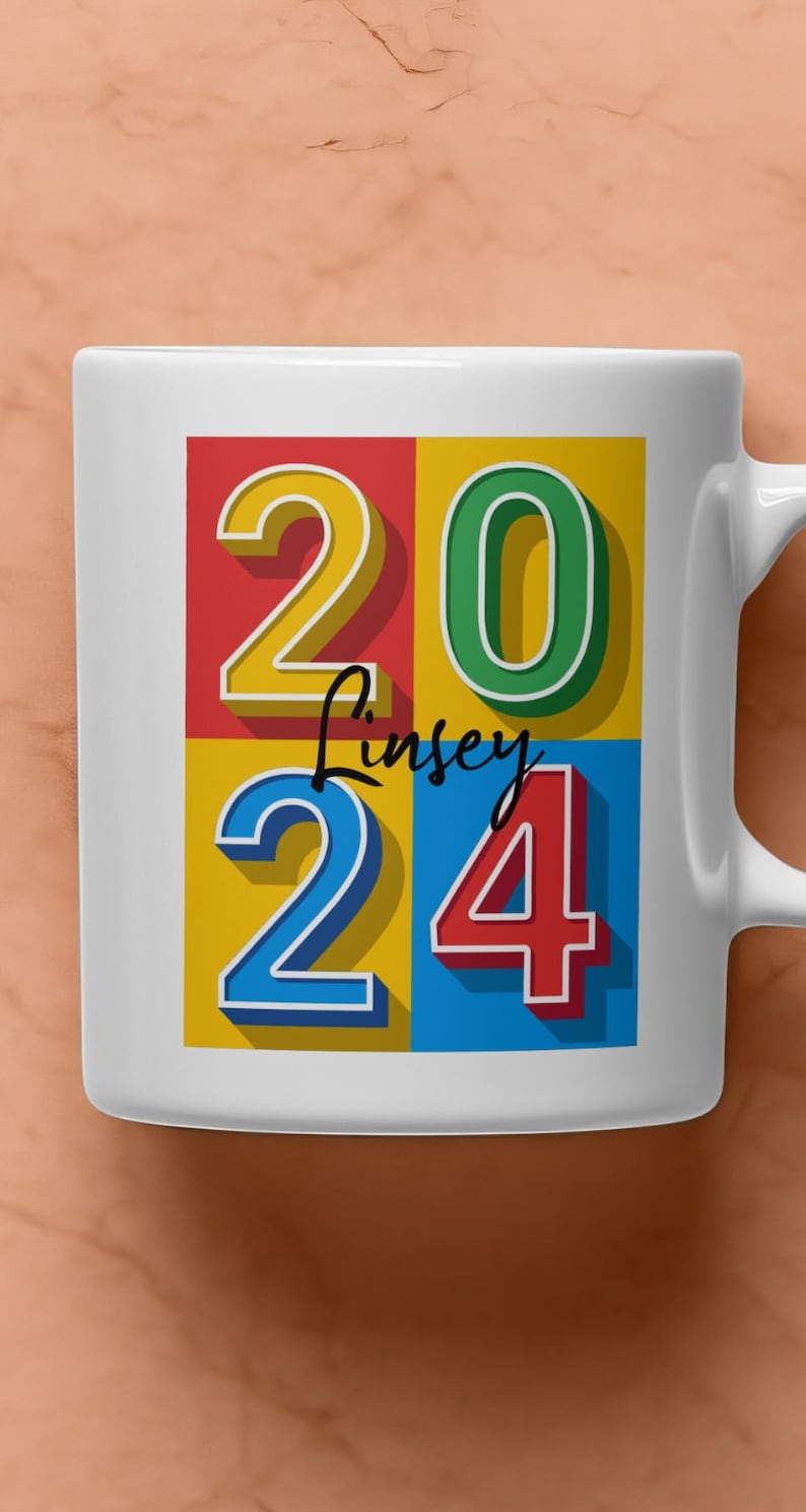 May include: White ceramic mug with a colorful design featuring the numbers 2024 in a retro style. The name "Lindsey" is written in black cursive script on the mug.