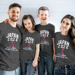 K&ouml;nnte beinhalten: Eine vierk&ouml;pfige Familie tr&auml;gt passende graue T-Shirts mit einem wei&szlig;en Aufdruck eines roten und wei&szlig;en Turms mit dem Text "JAPAN 2024" und "Murphy Family Trip".