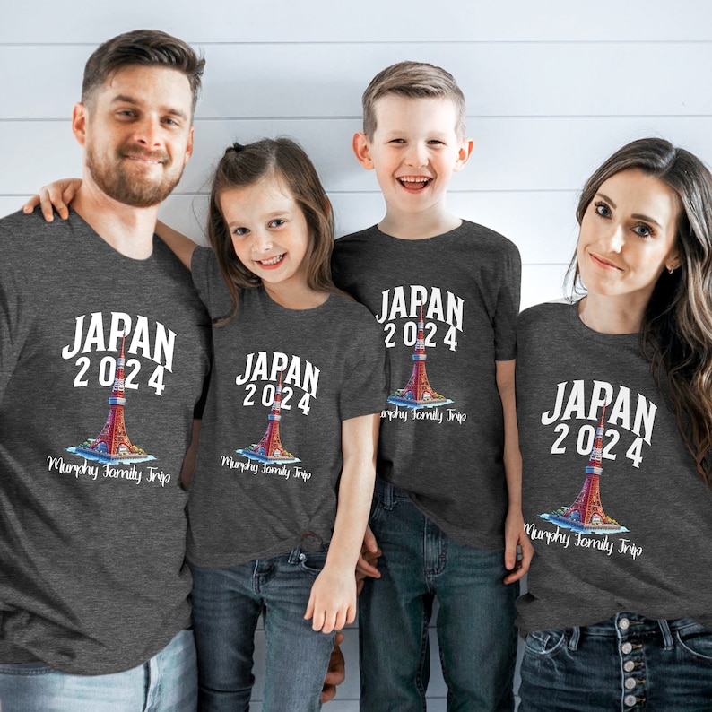K&ouml;nnte beinhalten: Eine vierk&ouml;pfige Familie tr&auml;gt passende graue T-Shirts mit einem wei&szlig;en Aufdruck eines roten und wei&szlig;en Turms mit dem Text "JAPAN 2024" und "Murphy Family Trip".