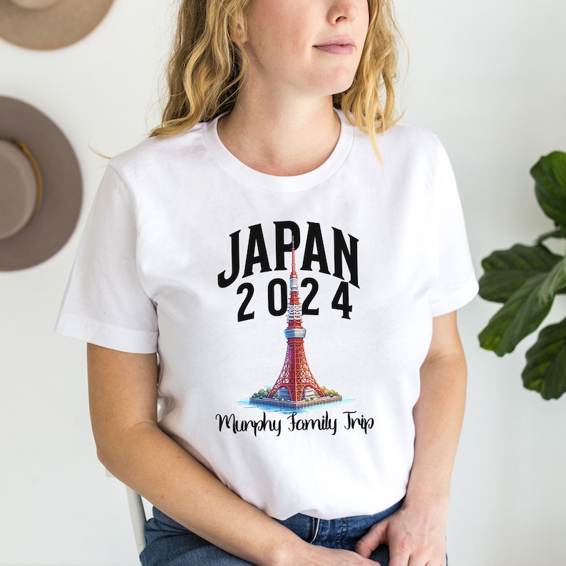 K&ouml;nnte beinhalten: Wei&szlig;es T-Shirt mit einer schwarzen Grafik der Tokyo Skytree, dem Text "JAPAN 2024" und dem Text "Murphy Family Trip".