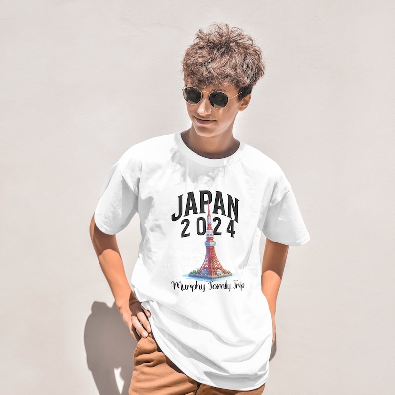 K&ouml;nnte beinhalten: Wei&szlig;es T-Shirt mit einem schwarzen Aufdruck eines Turms mit dem Text "JAPAN 2024" und "Murphy Family Trip" darunter.