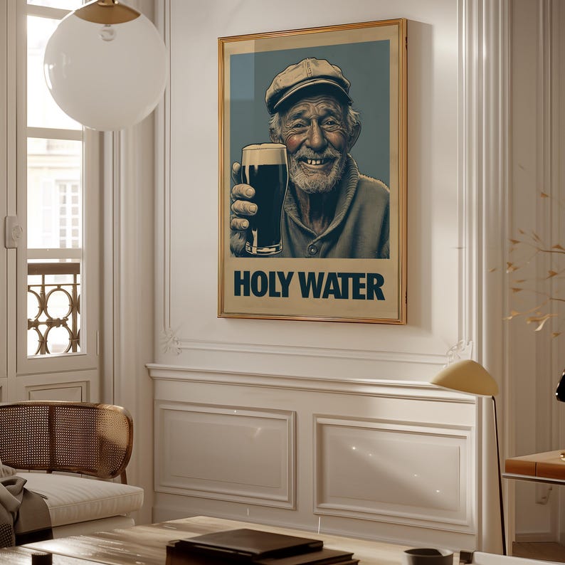 May include: Framed art print featuring a smiling elderly man holding a pint of dark beer. The artwork has a vintage style with the words "HOLY WATER" in bold letters at the bottom. The man is wearing a cap and a sweater.