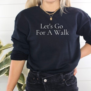 May include: A black sweatshirt with the text "Let's Go For A Walk" in white lettering.