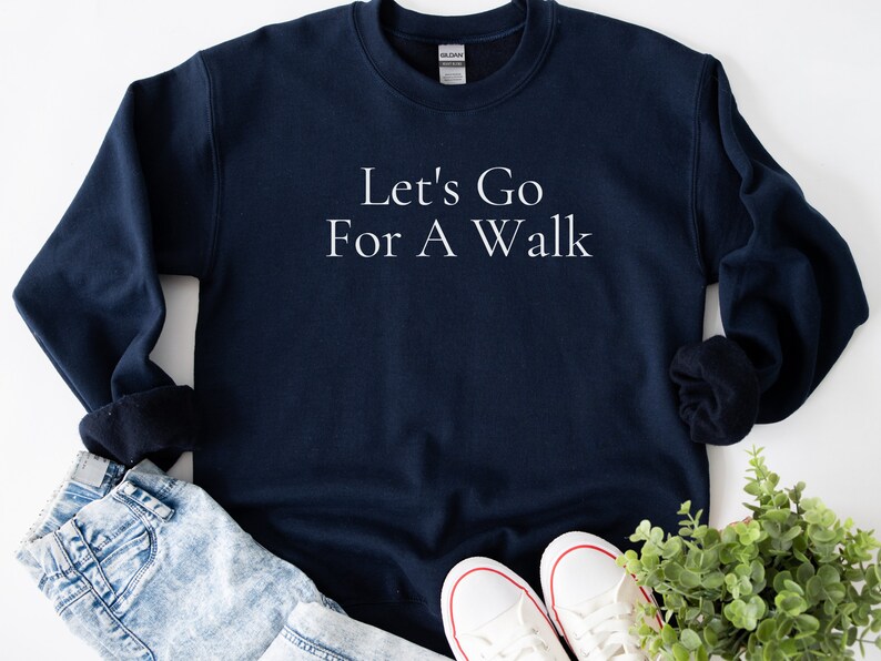 May include: A navy blue sweatshirt with the text "Let's Go For A Walk" in white lettering.