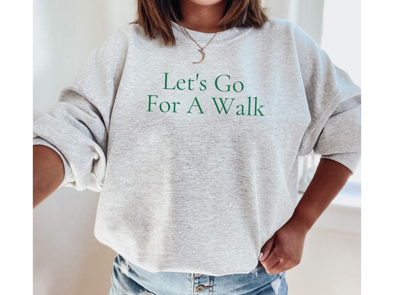 May include: A gray sweatshirt with the text "Let's Go For A Walk" in green lettering.