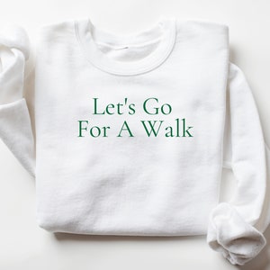 May include: White sweatshirt with green text that reads "Let's Go For A Walk".