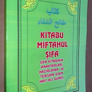 May include: A green book with gold decorative accents and text in multiple languages. The title "KITABU MIFTAHUL SIFA" is prominently displayed in red. The book's cover also features text in Arabic and Turkish.
