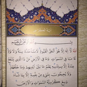 May include: A page from a Quran, a holy book for Muslims, with Arabic text and intricate decorative borders in blue, orange, and gold. The text is in black ink and includes the Arabic phrase "Bismillah ar-Rahman ar-Rahim" which translates to "In the name of Allah, the Most Gracious, the Most Merciful."
