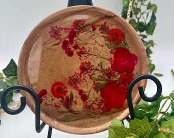 May include: A round wooden tray with a clear resin top featuring pressed red flowers and greenery.