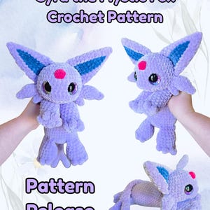 Puede incluir: An image announcing a crochet pattern release. It features a lavender fox plush with blue ear details, a pink spot on its forehead, and large, glittery eyes. The text reads "Cyra the Mystic Fox Crochet Pattern" and "Pattern Release".