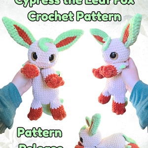 May include: A crocheted Cypress the Leaf Fox plushie in multiple poses. The plushie has a cream-colored body with green and orange accents on the ears, paws, and tail. The text "Cypress the Leaf Fox Crochet Pattern" and "Pattern Release" are visible.