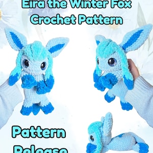 May include: A crocheted fox toy in shades of light blue and dark blue, with large, glittery eyes. The text "Eira the Winter Fox Crochet Pattern" and "Pattern Release" are displayed. The fox has large ears and is posed in multiple positions.