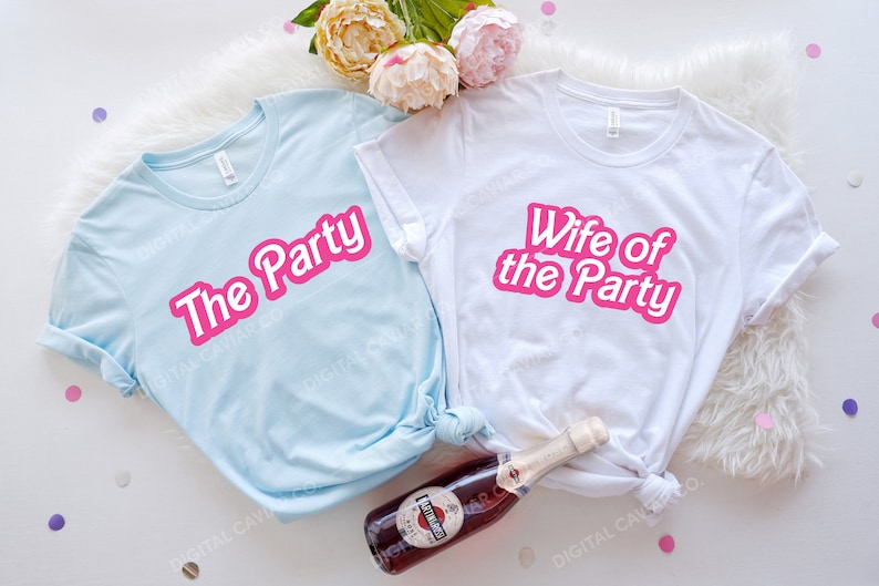 May include: Two white t-shirts with pink text. One shirt says "The Party" and the other says "Wife of the Party".