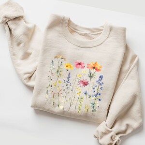 natural colored, beige folded sweatshirt with soft colored pressed flowers print, light and vibrant colors, spring feeling