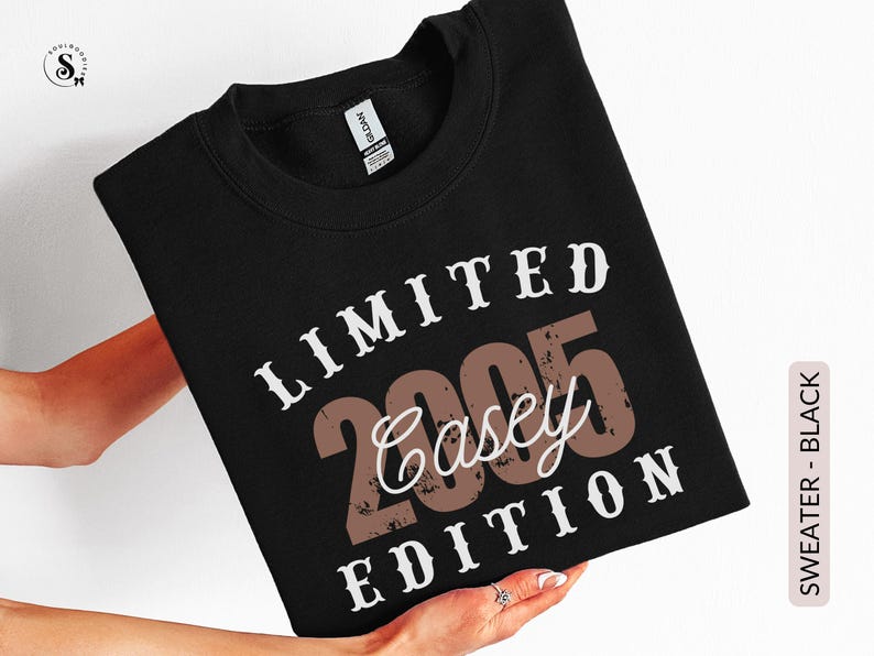 K&ouml;nnte beinhalten: Schwarzes Sweatshirt mit dem Text "LIMITED 2005 Casey EDITION" in Wei&szlig; und Braun. Das Sweatshirt hat einen Rundhalsausschnitt. Das Wort "SWEATER - BLACK" ist auf einem vertikalen Etikett auf der rechten Seite des Bildes aufgedruckt.