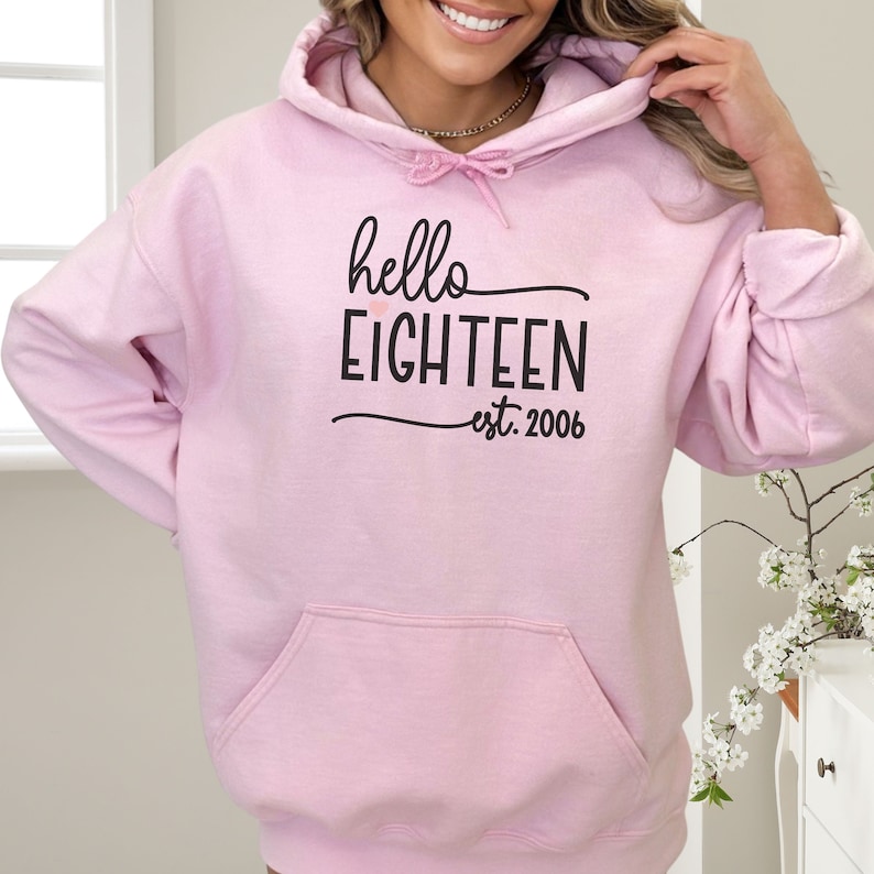 cute girl wearing oversize pink hoodie with hello 18 est 2006 print in front birthday gift for 18th Birthday trendy College Style