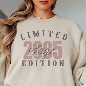 K&ouml;nnte beinhalten: Beiges Sweatshirt mit dem Text "LIMITED 2005 Sage EDITION" in einem Used-Vintage-Stil. Der Text ist in Braun- und Rosat&ouml;nen gehalten. Das Sweatshirt hat einen Rundhalsausschnitt und lange &Auml;rmel.