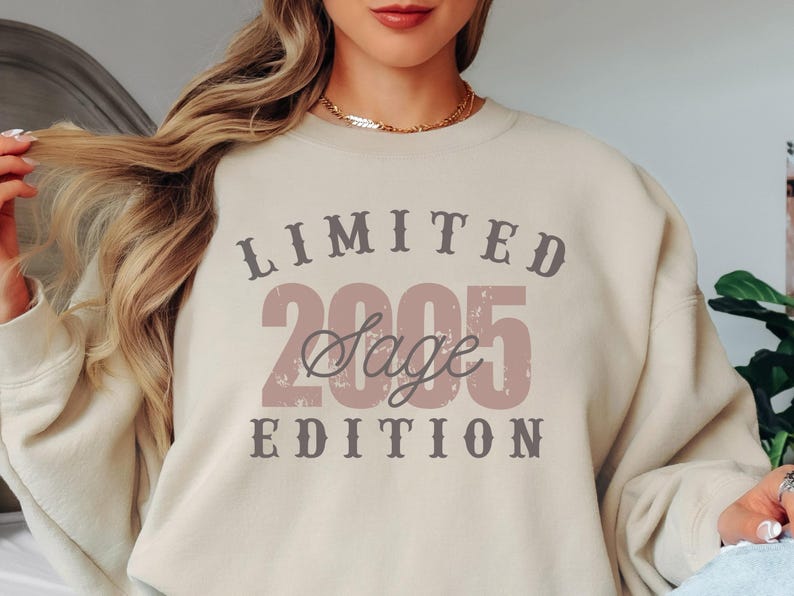 K&ouml;nnte beinhalten: Beiges Sweatshirt mit dem Text "LIMITED 2005 Sage EDITION" in einem Used-Vintage-Stil. Der Text ist in Braun- und Rosat&ouml;nen gehalten. Das Sweatshirt hat einen Rundhalsausschnitt und lange &Auml;rmel.