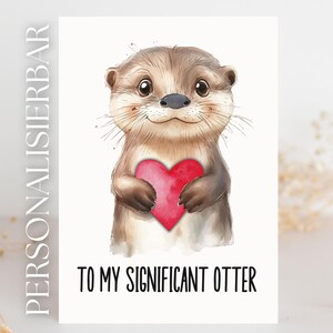 Könnte beinhalten: Eine Grußkarte mit einer Aquarellillustration eines Otters, der ein rotes Herz hält. Der Text "TO MY SIGNIFICANT OTTER" ist darunter gedruckt. Die Karte hat einen weißen Hintergrund.