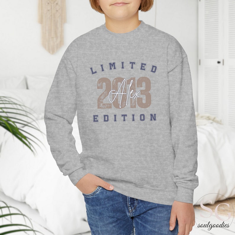 teenager child boy white room with a jeans and a grey  sweathirtand a print limited edition with custom name