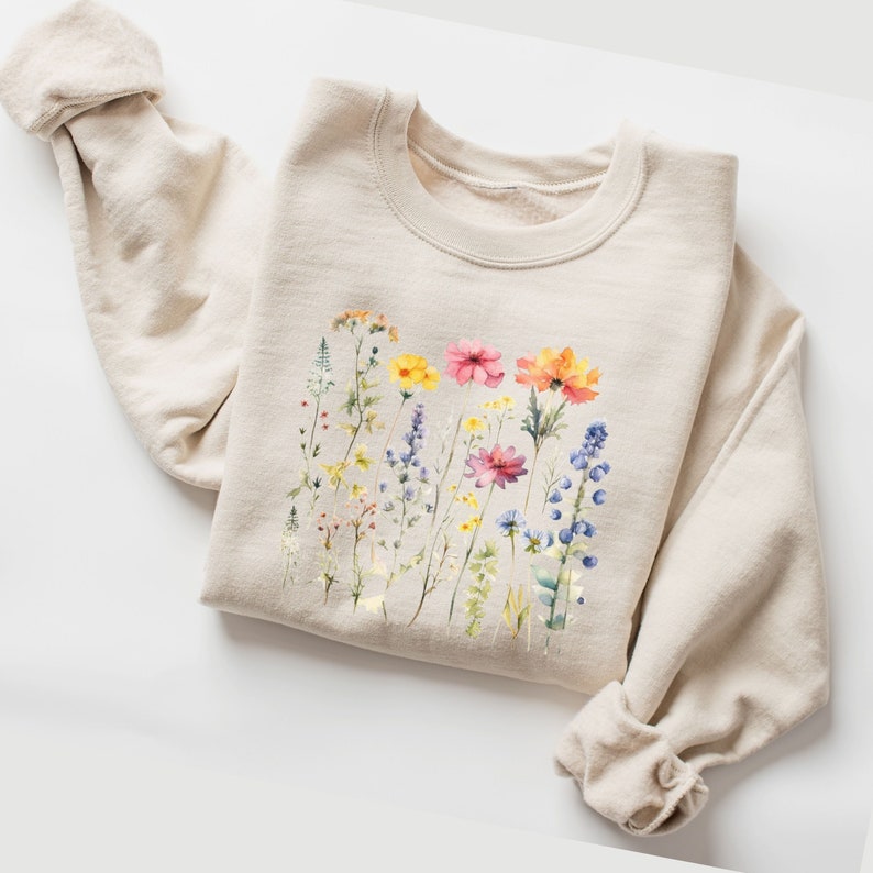 natural colored, beige folded sweatshirt with soft colored pressed flowers print, light and vibrant colors, spring feeling