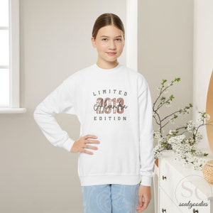 teenager child white room with a jeans and a white sweathirtand a print limited edition with custom name