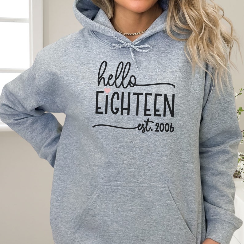 cute girl wearing oversize hoodie with hello 18 est 2006 print in front birthday gift for 18th Birthday trendy College Style