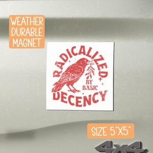 May include: A square, weather-durable magnet featuring a red raven illustration holding a sprig. The text reads "RADICALIZED BY BASIC DECENCY". The magnet measures approximately 12.7cm x 12.7cm.