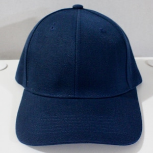 May include: A navy blue baseball cap with a curved brim. The cap has a six-panel design with a button on top. The fabric appears to be a sturdy, woven material. This classic style hat is suitable for casual wear.