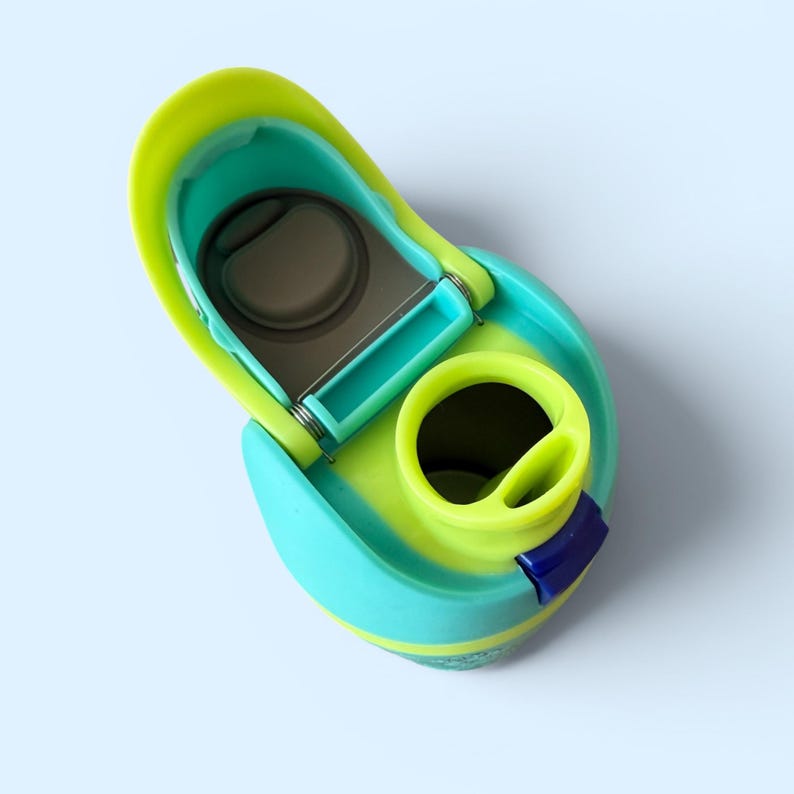 May include: A close-up of a water bottle lid in shades of teal, green, and yellow. The lid is open, revealing the drinking spout and a hinged mechanism. A small blue accent is visible.