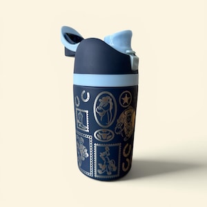 May include: A navy blue water bottle with a light blue lid and accents. The bottle features a repeating pattern of cowboy-themed illustrations in silver, including horses, boots, and stars. The lid is open, revealing the drinking spout.