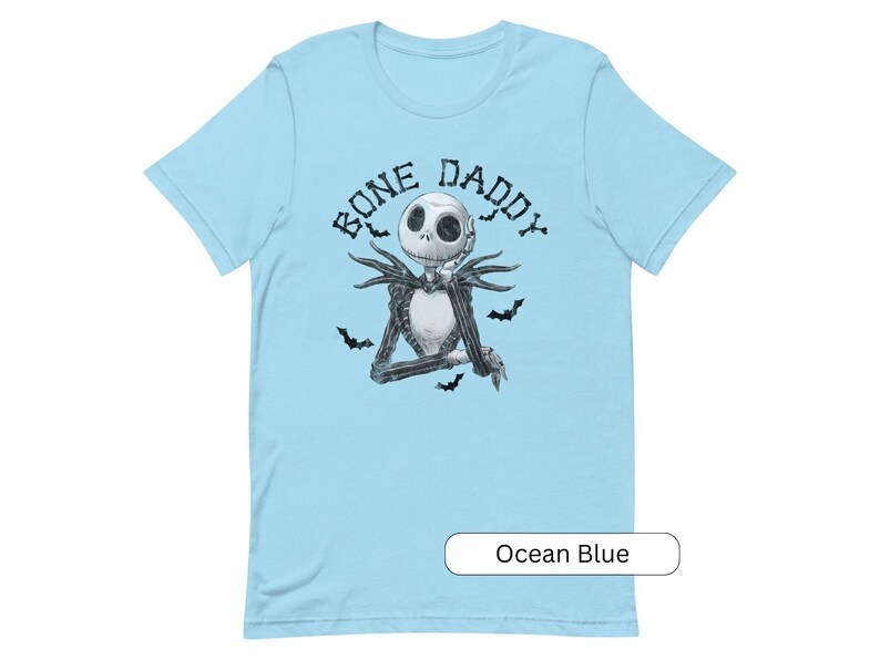 Puede incluir: Una camiseta azul claro con una ilustraci&oacute;n en blanco y negro de Jack Skellington de Pesadilla antes de Navidad. El texto "Bone Daddy" est&aacute; impreso sobre la ilustraci&oacute;n.