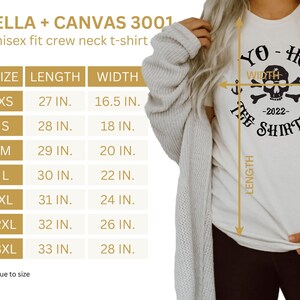 Puede incluir: Una camiseta blanca unisex con un gr&aacute;fico negro de calavera y huesos cruzados que dice "Yo-Ho The Shirt Co. -2022-". La camiseta es una Bella + Canvas 3001 y est&aacute; disponible en tallas XS-3XL. Se incluye una tabla de tallas con las medidas de longitud y ancho en pulgadas.