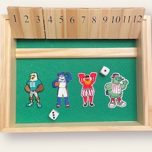 May include: A wooden game board with 12 numbered slots and a green felt playing surface. There are four character figures on the board, a green monster, a red and white figure, a blue figure, and a green and white eagle. There are two white dice on the board.