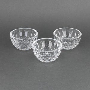 May include: Three clear glass bowls with a cut crystal design. The bowls are round and have a slightly flared lip.