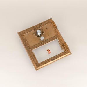 May include: A brass mailbox with a glass window and a number "3" on the front. The mailbox has a decorative design around the edges.