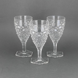 May include: Three clear glass wine glasses with a diamond pattern. The glasses have a hexagonal base.