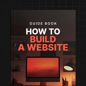 May include: A guide book with the title "How to Build a Website" in red text on a black background. The book is on a desk with a computer monitor, a lamp, and a cup.