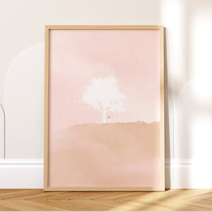Puede incluir: Una impresión enmarcada con un diseño de estilo acuarela de un árbol blanco sobre un fondo rosa y melocotón.