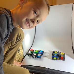 The child LEGO brick race car designer behind the Arts and Bricks wallstickers. Shows photographing the custom built LEGO race cars.