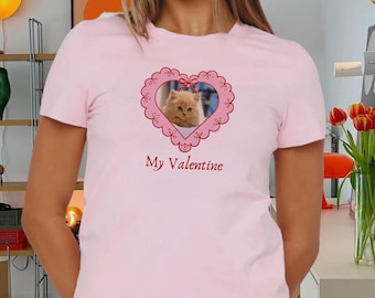 Puede incluir: Una camiseta rosa con un gráfico en forma de corazón que presenta un gato en su interior. El texto "My Valentine" está impreso debajo del corazón.