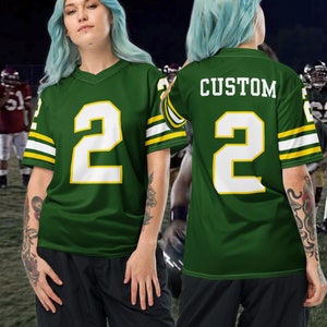 May include: Green and white football jersey with the number "2" on the front and back. The jersey has yellow and white stripes on the sleeves. The text "CUSTOM" is printed on the back of the jersey.