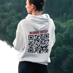 May include: A white hoodie with a black and white QR code and the text "Wanna Date?" printed on the back.