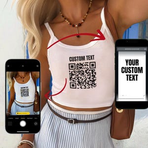 Könnte beinhalten: Weißes Tanktop mit dem Text "CUSTOM TEXT" und einem QR-Code. Das Top wird mit einem gestreiften Rock und einem braunen Gürtel getragen. Ein Telefon zeigt den Text "YOUR CUSTOM TEXT".