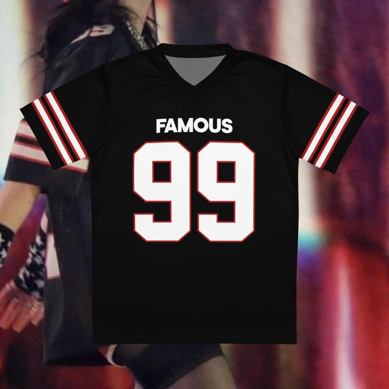 May include: Black jersey with white "FAMOUS" text and the number "99" in white with a red outline. The sleeves have white stripes with a red accent. The jersey has a V-neck collar.