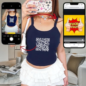 Puede incluir: Top sin mangas azul marino con un código QR blanco. Se combina con una minifalda blanca con volantes. Un teléfono muestra un sitio web con un gráfico de dedos medios.