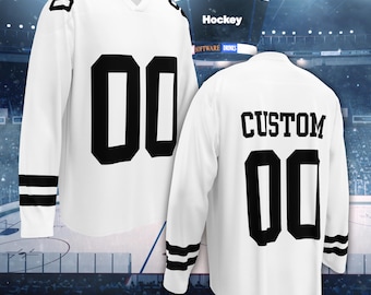 Puede incluir: Una camiseta de hockey blanca con los números 00 en negro en la parte delantera y las mangas. La parte trasera muestra la palabra CUSTOM en letras negras sobre el número 00. Las mangas tienen dos rayas horizontales negras.