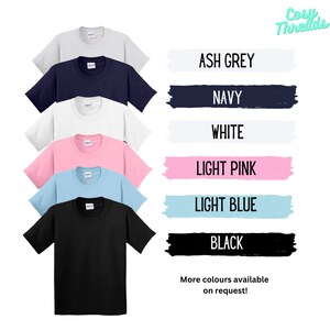 May include: A selection of t-shirts in a range of colours, including ash grey, navy, white, light pink, light blue, and black. The shirts are shown against a white background with the text "Cosy Threads" and "More colours available on request!"