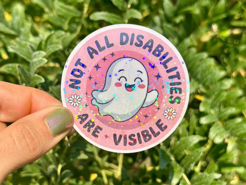 May include: A round sticker with the text "NOT ALL DISABILITIES ARE VISIBLE" in pink and white. The sticker features a smiling ghost illustration with a holographic effect, surrounded by stars and daisies.